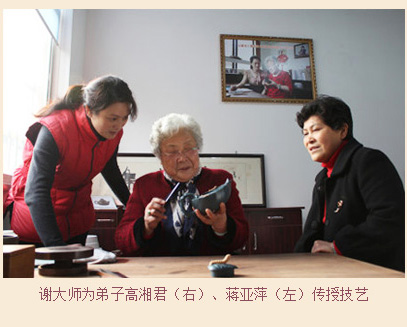 谢曼伦大师为弟子高湘君（右）、蒋亚萍（左）传授技艺