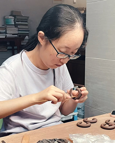 鲍璟在专心制作紫砂壶